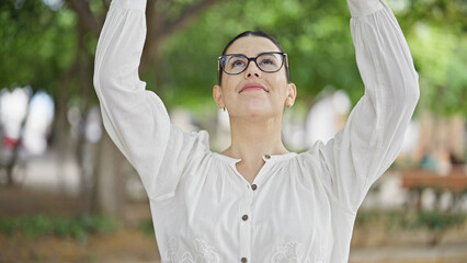 Wall Mural - Young beautiful hispanic woman with open arms at the park