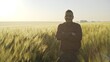 © procinemastock - Back view of man standing with hands apart in green wheat field enjoying sunlight and harmony with nature - slow motion