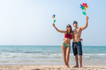 Wall Mural - Happy romantic moment couple enjoying sunny day at the beach, man and woman smile and look relaxed, romance, vacation, beach life, summer holiday relaxation and summer fun, love by the sea concept.