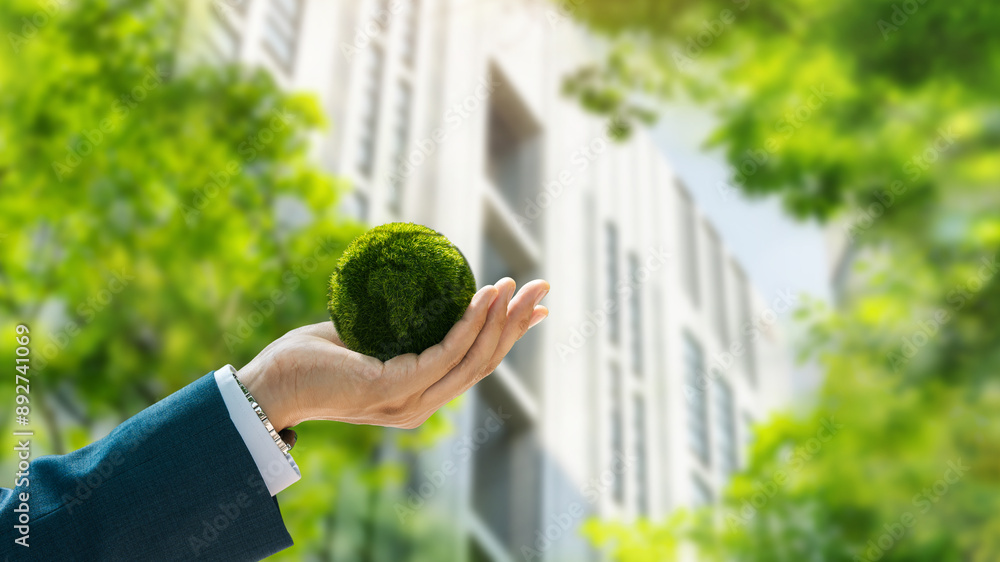 Environmental concept. Green globe in the hands of a businessman with ...