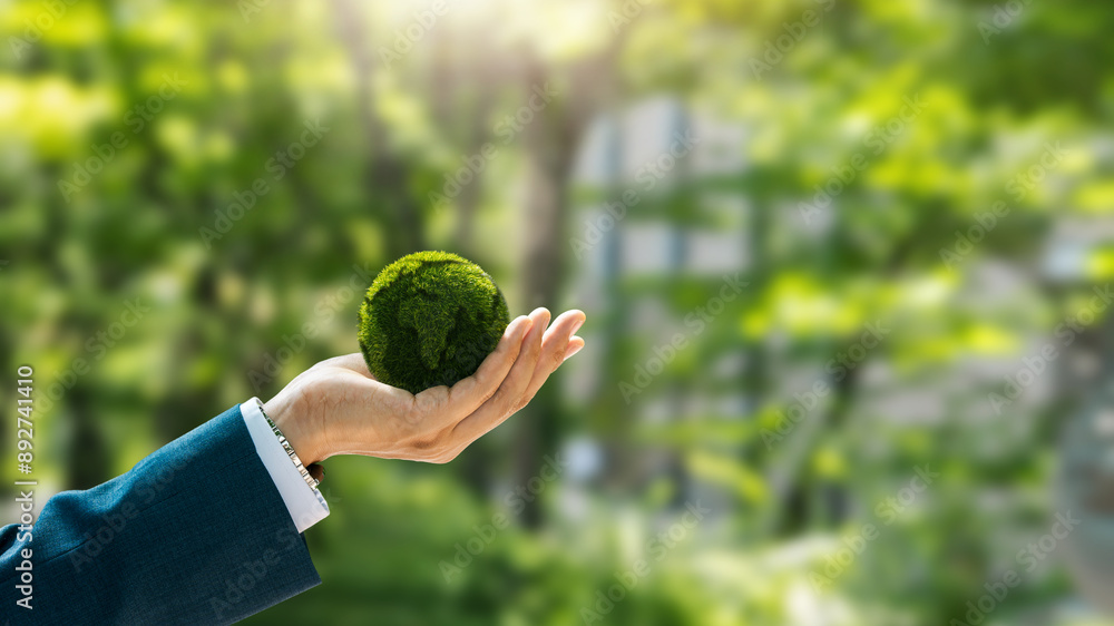 Environmental concept. Green globe in the hands of a businessman with ...