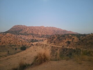 Scenic view of sand dune valley and mountain in a village in Rajasthan.