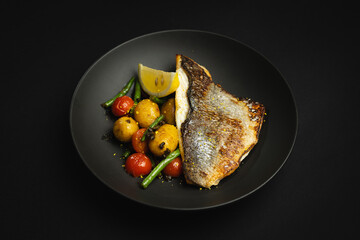 Wall Mural - Fish fillet with grilled vegetables on a black background, restaurant food serving, banquet.