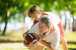 © famveldman - Family playing American football. Kids play rugby
