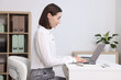 © New Africa - Woman with good posture working in office
