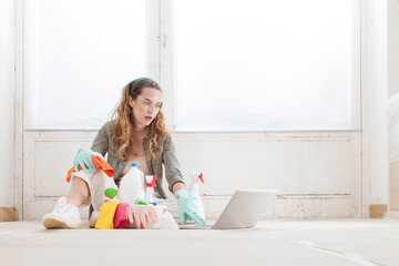 Wall Mural - A worried, tired, and astonished woman looking at computer laptop, searching for ways to remove mold. Household cleaning products or mold remediation service before renovating and painting the house