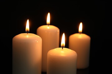 Wall Mural - Many burning candles on black background, closeup