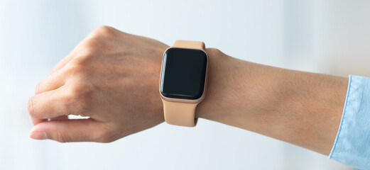 Fototapete - Close up cropped view of female hand with smart watch with black blank screen, selective focus, blurred background. Smartwatch - modern digital gadget with empty display, copy space