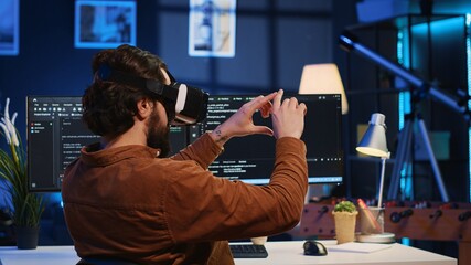 remote software developer using vr goggles in personal office at home to do javascript programming. 