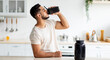 © Prostock-studio - Young Arab guy drinking protein shake from bottle at kitchen, copy space. Millennial Eastern man using meal replacement for weight loss, having sports supplement for muscle gain. Body care concept