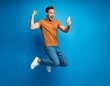 © Elit studio - A man is jumping in the air with his arms raised and a cell phone in his hand