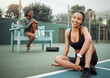 © peopleimages.com - Tennis court, exercise and portrait of woman on floor for fitness, healthy body and break in training. Happy, friends and athlete with smile on ground for sports practice, satisfaction and confidence
