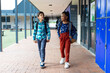 © wavebreak3 - Biracial boy and girl walk past lockers at school