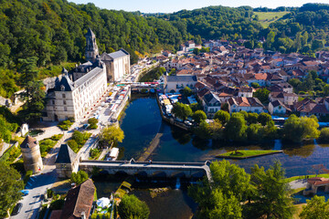 Wall Mural - Picturesque aerial view of summer cityscape of Brantome en Perigord looking out over medieval abbey on banks of Dronne River, France..