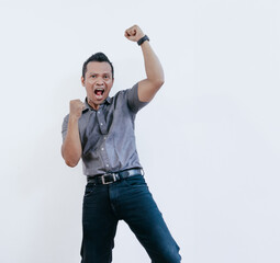 Excited cheerful asian businessman standing isolated on white background, celebrating success.