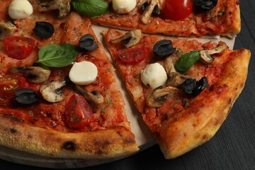 Wall Mural - Tasty pizza on black wooden table, closeup