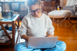 © simona - One adult woman have fun and enjoy using laptop at home in indoor leisure activity online with on the floor in living room. People and dating website or managing house economy. Working remote smart