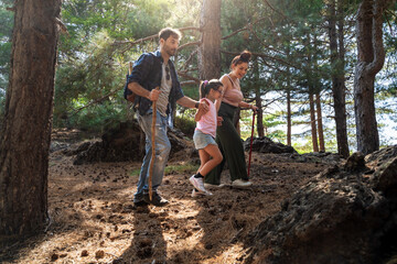 family hiking in pine forest, parents and daughter exploring nature, outdoor adventure and active li