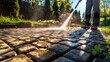 © Achmad Khoeron - Power Washing Garden Cobble Stone Paths. Outdoor Cleaning Using Pressure Washer