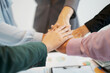 © S K Tu Mai - Close-up top view of young business team people putting their hands together background with business graph.