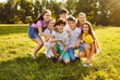 © Studio Romantic - Happy children friends standing together outdoors, having fun and smiling in the park on holidays enjoying spending time in a summer camp. Portrait of a kids looking at camera on the lawn in nature.