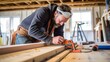 © VisualVortex - Skilled contractor measuring wood for trim work while renovating a home