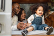 © Nassorn - Happy multiracial family having fun relaxing together. Portrait of multiethnic father mother and little biracial daughter playing at backyard camping. Diverse ethnic dad mom leisure with afro kid