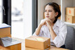 © David - Asian woman think hard serious working of sme laptop computer at home selling online start up small business owner, e-commerce ideas concept.