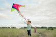 © Westend61 - Happy boy running with kite and brother in background