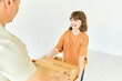 © Westend61 - Happy daughter helping father carrying cardboard box in new house