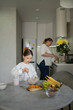 © Westend61 - Girl making fruit salad with mother working in kitchen at home