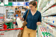 © Westend61 - Woman buying milk from refrigerated section at supermarket