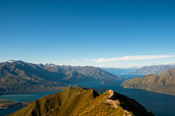 an idyllic mountain landscape under a clear sky, featuring rolling hills and a distant horizon, crea