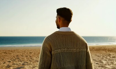 Wall Mural - Portrait of a Saudi Arabian man in his 20s in a beach background wearing a chic cardigan