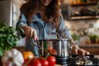 © Straxer - Female using steel metallic pot for preparing in the kitchen. Kitchenware for cooking.