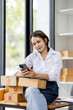 © David - Starting small businesses SME owners asian female entrepreneurs Using phone on receipt box and check online orders to prepare to pack the boxes, sell to customers, SME business ideas online.