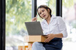 © David - Portrait business woman smile and use laptop checking information on parcel shipping box before send to customer. Entrepreneur small business working at home. SME business online marketing.