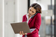 © David - Portrait of young asian financial woman sitting at desk and working on laptop while making call phone