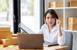 © David - SME concept. Young asian female ecommerce business owner prepares package box for customer and delivery check balance.  SME small business entrepreneur SME or freelance