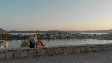 Wall Mural - Enjoying vacation in Greece. Young traveling woman enjoying sunset on the view point. Ermioni bay and yacht marina.