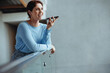 © Jacob Lund - Happy business woman speaking in a phone call conversation on an interior balcony