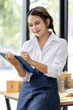 © David - Startup small business entrepreneur SME, asian woman checks stock on clipboard and parcels at home ,Success small business owner online sell marketing delivery, SME e-commerce telemarketing concept