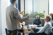 © Jacob Lund - Business man giving an explanation of his goals for the company in a team meeting