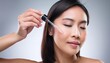 © Eggy - Asian Woman holding a Pipette with Skincare Serum - Applying Serum to her Face - Hyaluronic Acid, Anti Aging, Moisturiser, Repair, Hydrating, Vitamin, Ascorbic, Retinol, Exfoliant, Azelaic