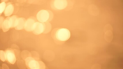 Wall Mural - Abstract Blurred video screensaver bokeh golden sea at sunset. The sun reflects and sparkles on the waves.