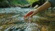 © Khalil - A female hand touching the river water