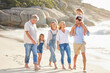 © peopleimages.com - Beach, walking and children with parents and grandparents on summer vacation, adventure or holiday. Holding hands, love and family with generations by ocean for tropical weekend trip in Australia.