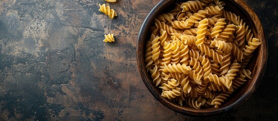 Aufkleber - Top view of uncooked Creste di Gallo pasta presented in a wooden bowl on a dark vintage backdrop with room for text or other graphics in the image. with copy space image