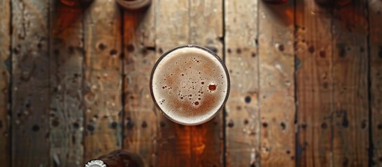 Aufkleber - Top view of a beer glass on a wooden table with beer bottles around it The image features selective focus and a blank template for copy space