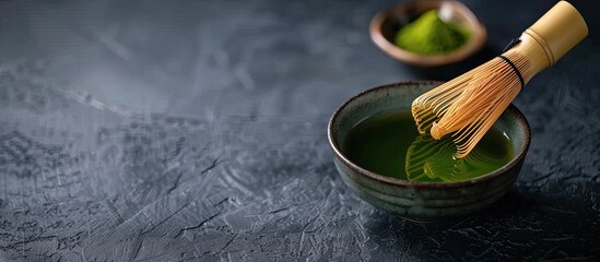 Aufkleber - Close up of a fresh cup of matcha tea displayed on a dark grey table with a bamboo whisk creating a visually appealing setting with copy space image
